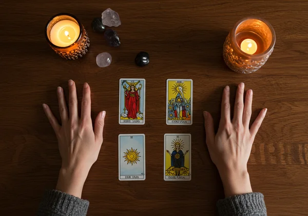 Woman's hands choosing a tarot card from a spread.